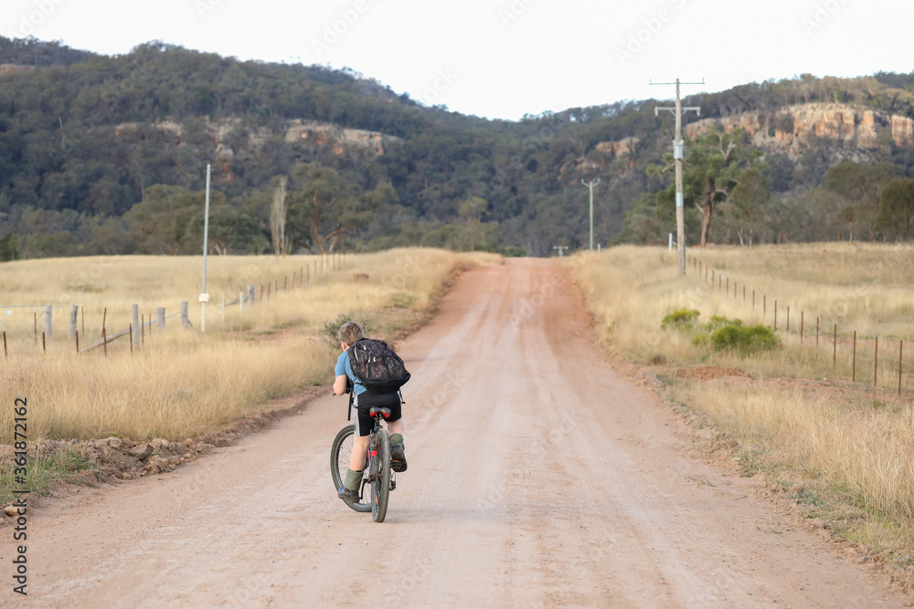 Children riding bikes on remote country lane Children riding bikes on remote country lane