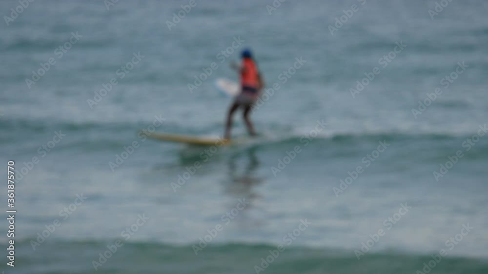 blur surfers with surfboard on the sea in sunny day blur surfers with surfboard on the sea in sunny day