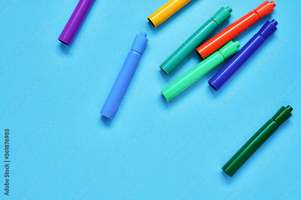 Colorful felt tip pens on blue backdrop. Top view, copy space. Back to school concept. Colorful felt tip pens on blue backdrop. Top view, copy space. Back to school concept.