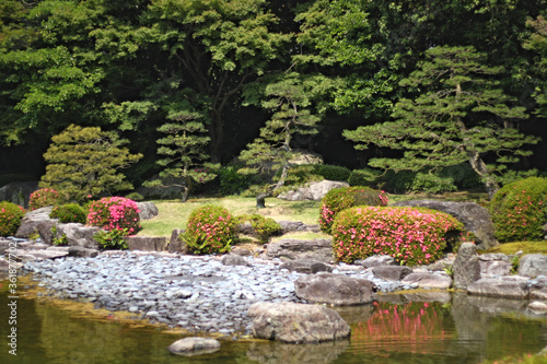 Bilde på lerret Picturesque landscape in japanese garden with trees and a creek locus amoenus in