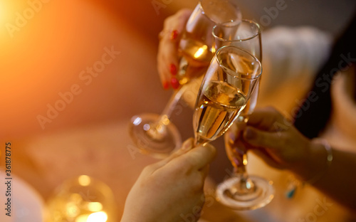 glasses of toast chin chin, hands with glasses of white wine in cafe photo