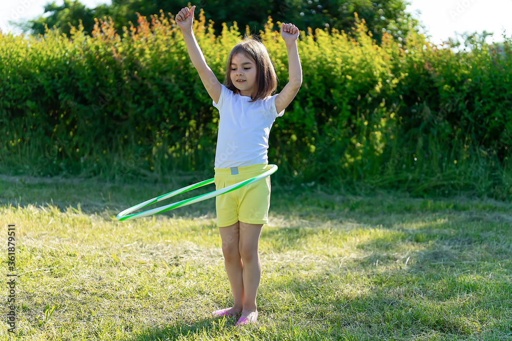 Little girl doing sports in the park. Hulahup Games Little girl doing sports in the park. Hulahup Games