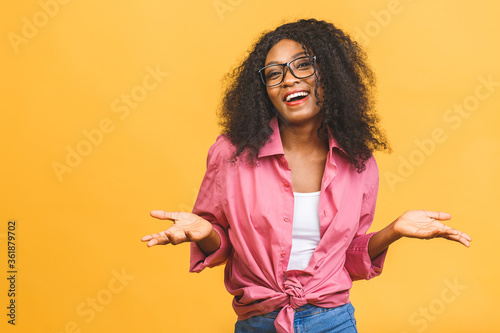 Foto Portrait of cheerful young african american woman with curly hair posing in studio with happy smile
