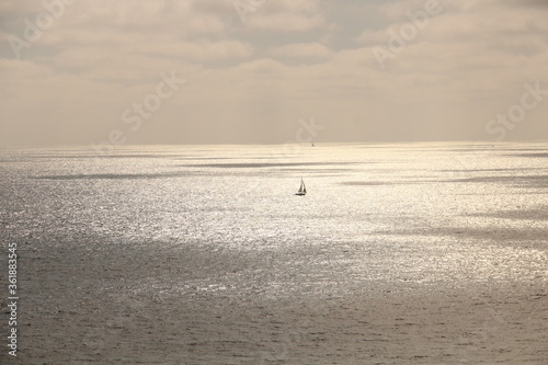 Lone sailboat in the vast ocean.