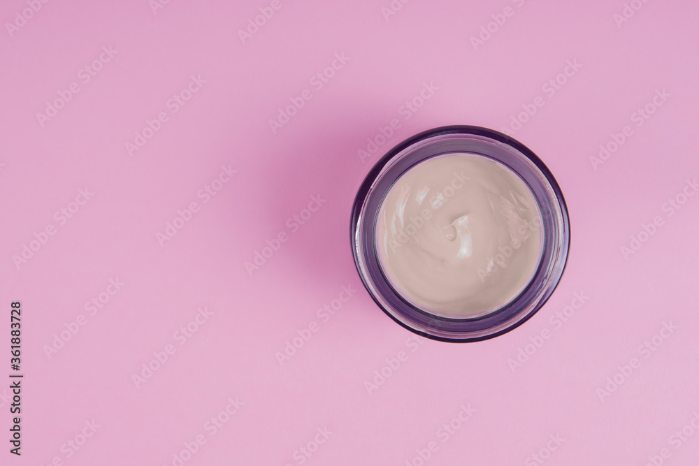 Open jar with face cream on a pink background. Face care concept Open jar with face cream on a pink background. Face care concept