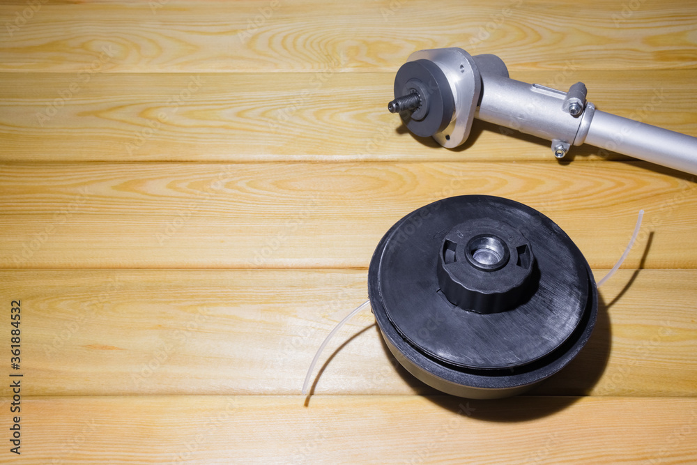 the grass trimmer. details on a wooden background.the view from the top the grass trimmer. details on a wooden background.the view from the top