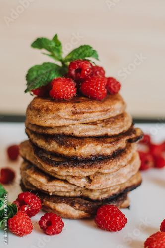 Chocolate pancakes with fresh raspberries and mint on black background