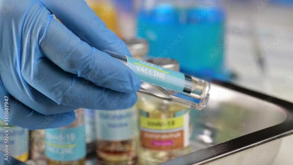 hand of scientist doctor holding vial ampoule bottle human use vaccine syringe injection coronavirus covid19 at hospital lab. Researcher in laboratory Try to extract vaccine for virus covid19 Success. hand of scientist doctor holding vial ampoule bottle human use vaccine syringe injection coronavirus covid19 at hospital lab. Researcher in laboratory Try to extract vaccine for virus covid19 Success.