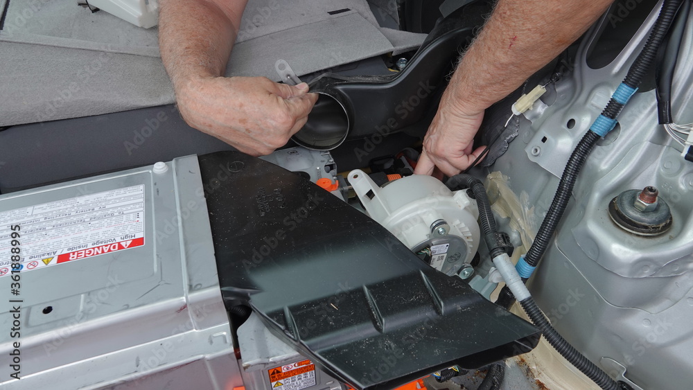 A man's hand pointing to location of hybrid battery fan in 2011 Toyota Prius. A man's hand pointing to location of hybrid battery fan in 2011 Toyota Prius.