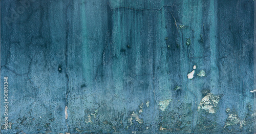 dark and light blue wall with peeling paint and chipped - rough texture for a damaged background wallpaper