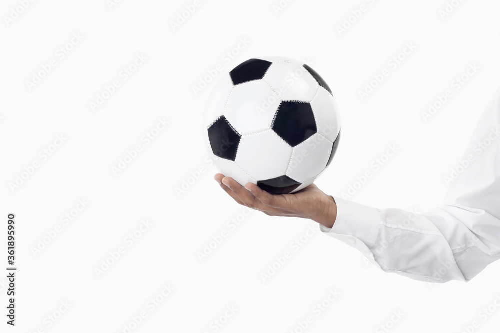 Soccer manager holding a ball with one hand Soccer manager holding a ball with one hand