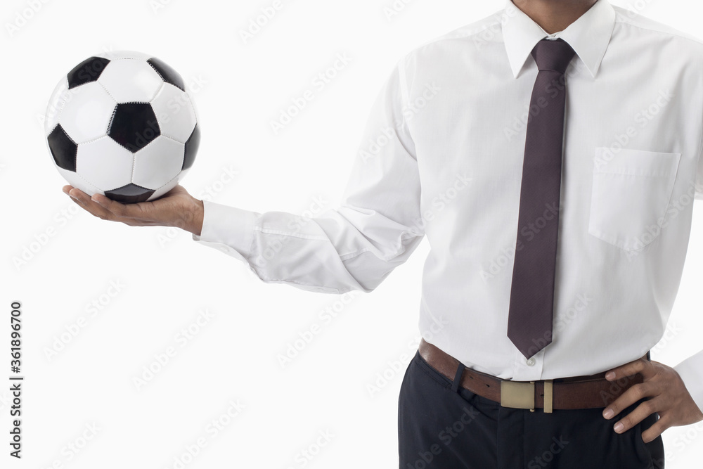 Soccer manager holding a ball with one hand