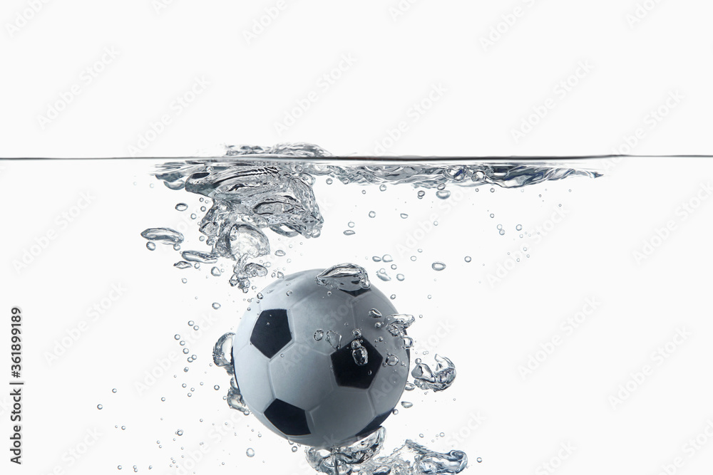 Naklejka premium Soccer ball splashing into water