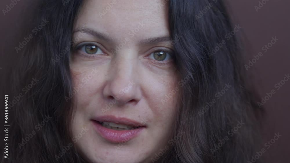 Close up of adult woman face during conversation, attractive woman thinking, talking, smiling. Portrait of female person with long hair beautiful brown eyes, natural human beauty.