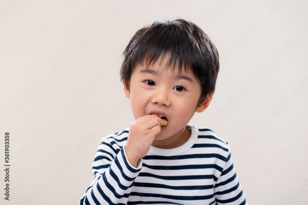 Kid boy eat cookie on white background Kid boy eat cookie on white background