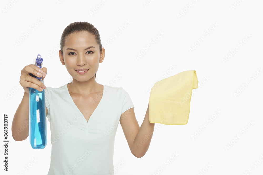 Woman holding up a cloth and a spray bottle Woman holding up a cloth and a spray bottle