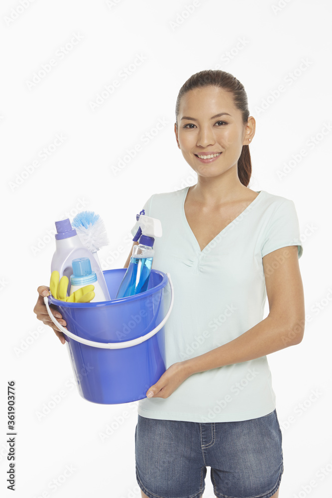 Woman holding a bucket filled with cleaning supplies Woman holding a bucket filled with cleaning supplies