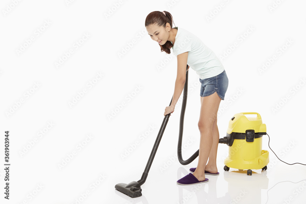 Woman cleaning and vacuuming the floor Woman cleaning and vacuuming the floor