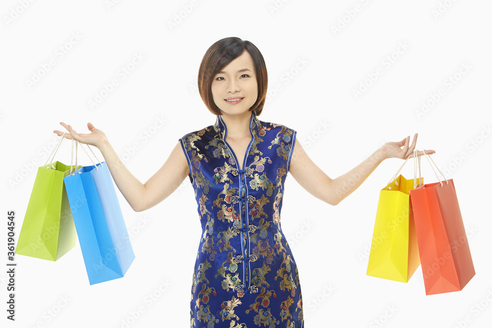 Cheerful woman in traditional clothing carrying paper bags