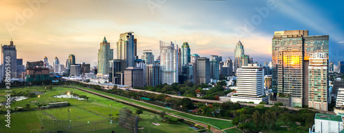 Panorama of Bangkok City, Business district with Football Field at dusk