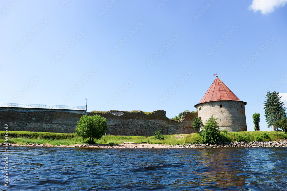 Corner tower of medieval Shlisselburg (Oreshek) fortress on the island in the Ladoga lake in Russia against blue sky