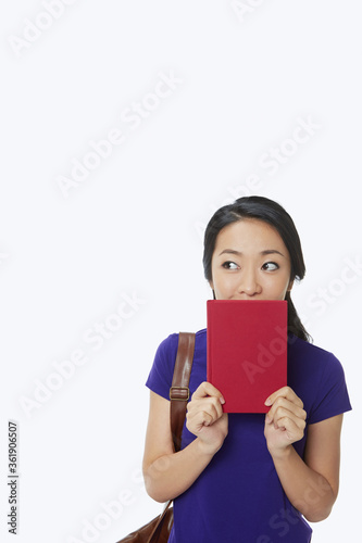 Woman covering her mouth with a book