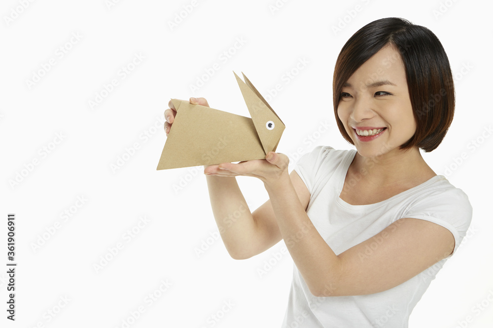 Cheerful woman holding up a paper rabbit Cheerful woman holding up a paper rabbit