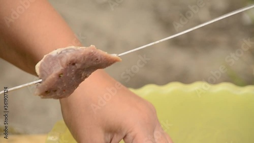 Stringing meat on a skewer closeup