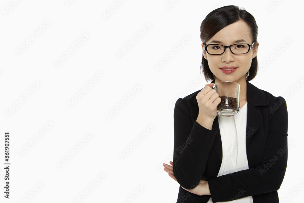 Businesswoman holding a cup filled with coffee beans Businesswoman holding a cup filled with coffee beans