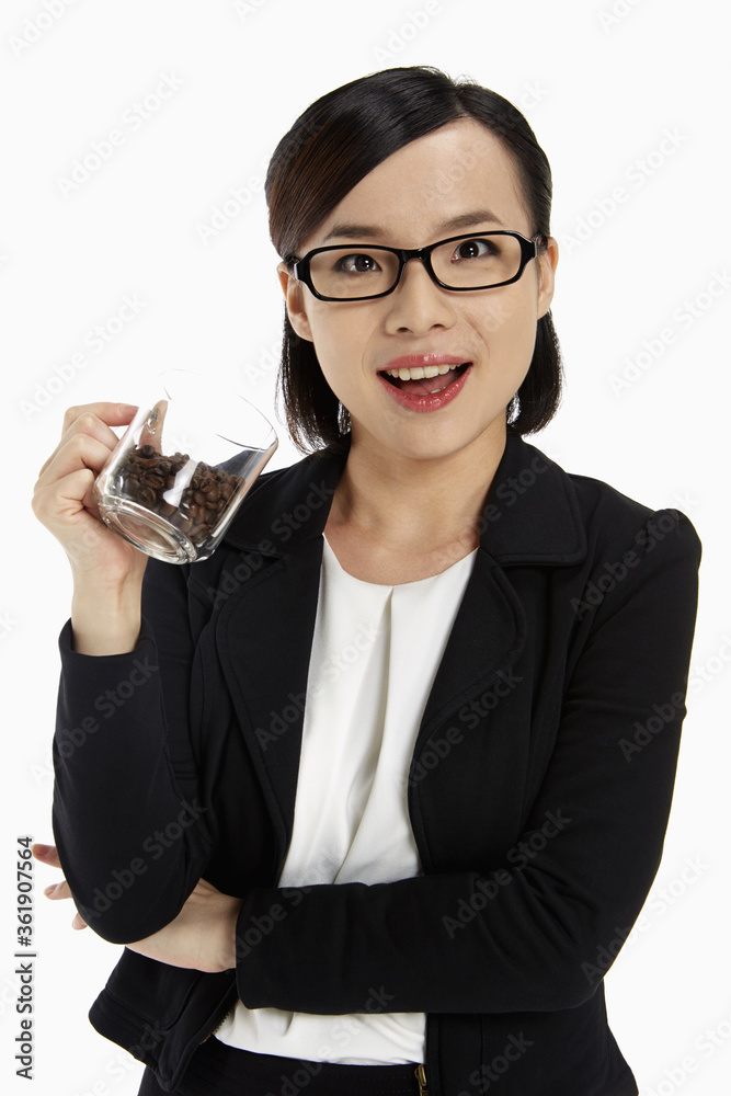 Businesswoman holding a cup filled with coffee beans Businesswoman holding a cup filled with coffee beans