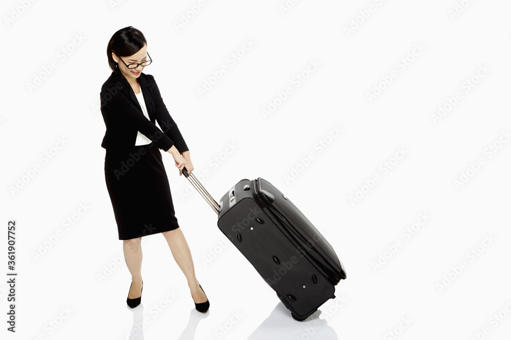 Businesswoman pulling a heavy luggage bag Businesswoman pulling a heavy luggage bag