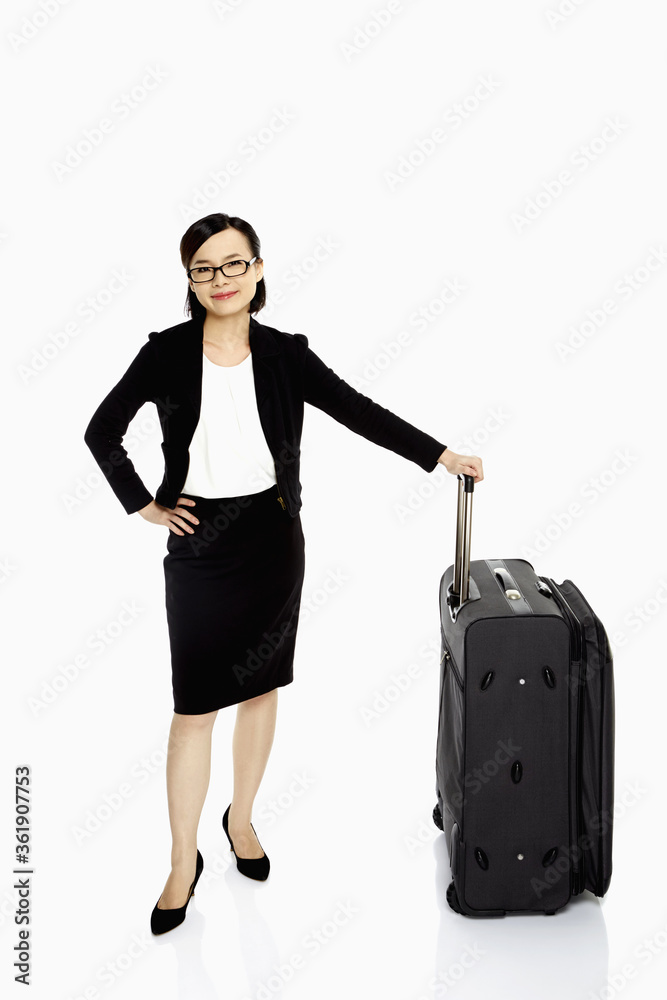 Businesswoman standing with a luggage bag, smiling Businesswoman standing with a luggage bag, smiling