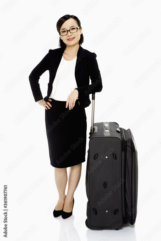 Businesswoman standing with a luggage bag, smiling Businesswoman standing with a luggage bag, smiling