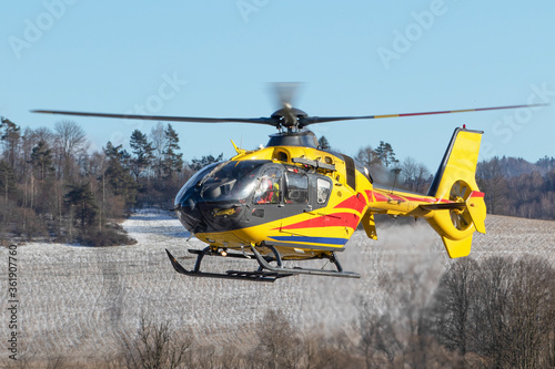 Rescue helicopter in flight over capped mountains