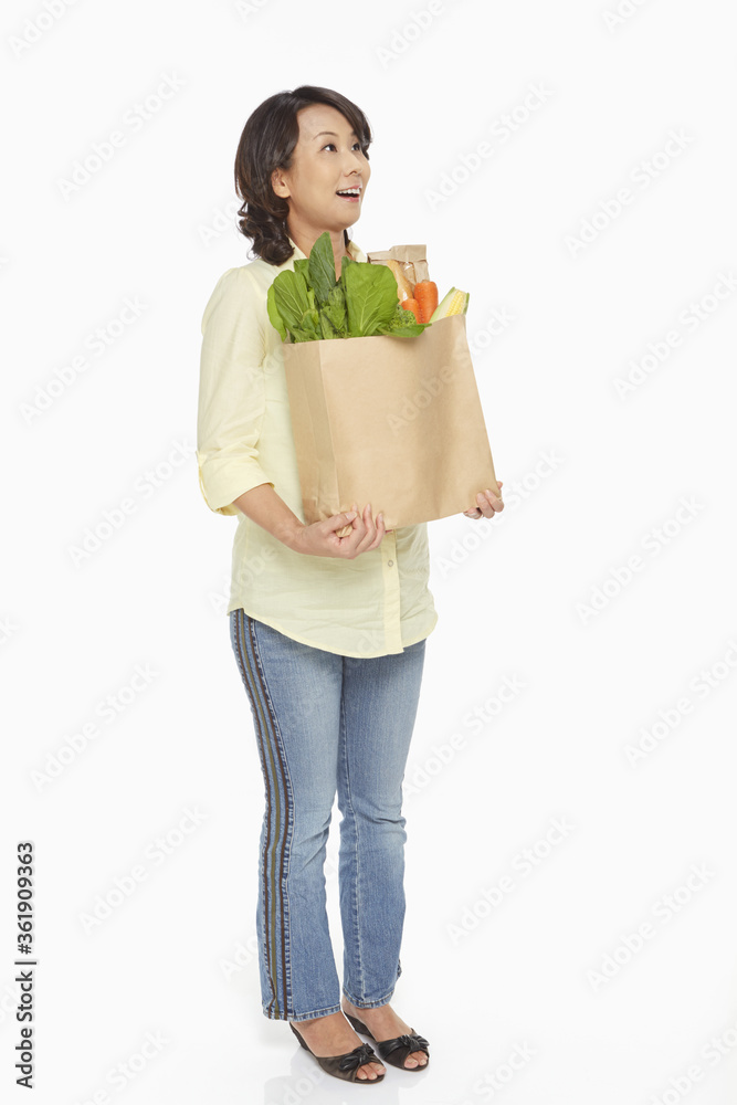 Woman carrying a bag of groceries Woman carrying a bag of groceries