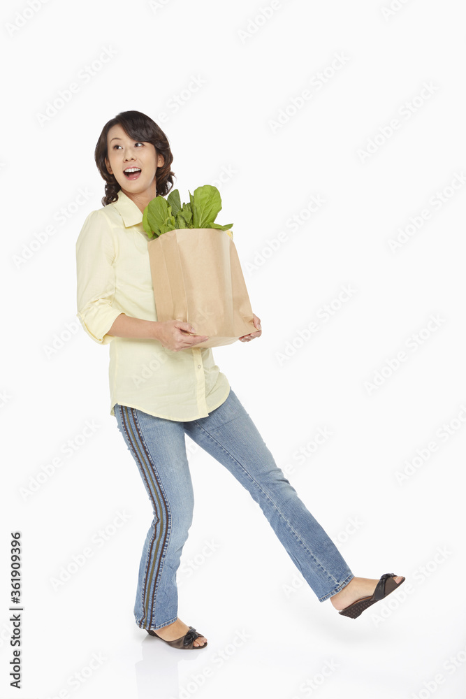 Woman carrying a bag of groceries Woman carrying a bag of groceries