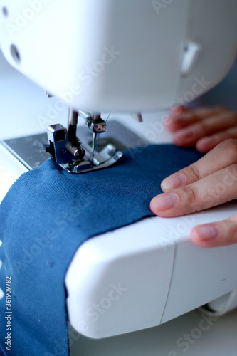  Girl sews from a knit fabric on a sewing machine
