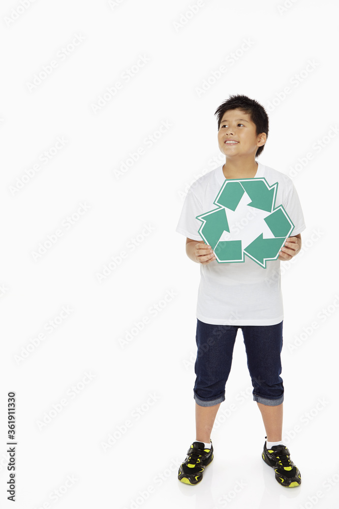 Boy holding up a Recycle logo