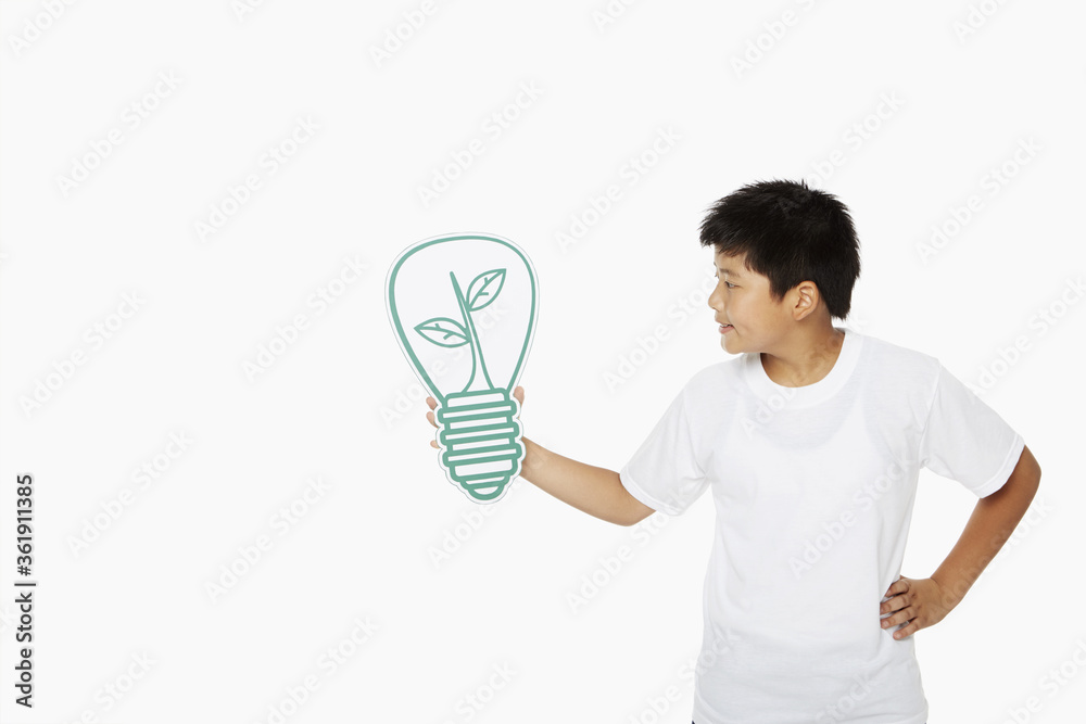 Cheerful boy holding up a cut out light bulb Cheerful boy holding up a cut out light bulb
