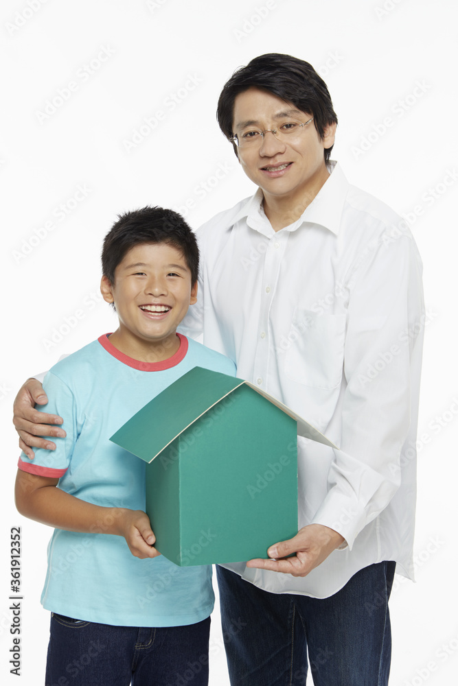 Obraz premium Father and son holding a cardboard house