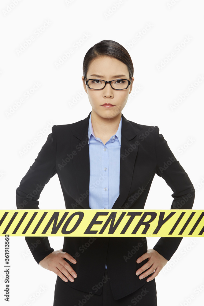 Businesswoman standing behind a No Entry sign Businesswoman standing behind a No Entry sign