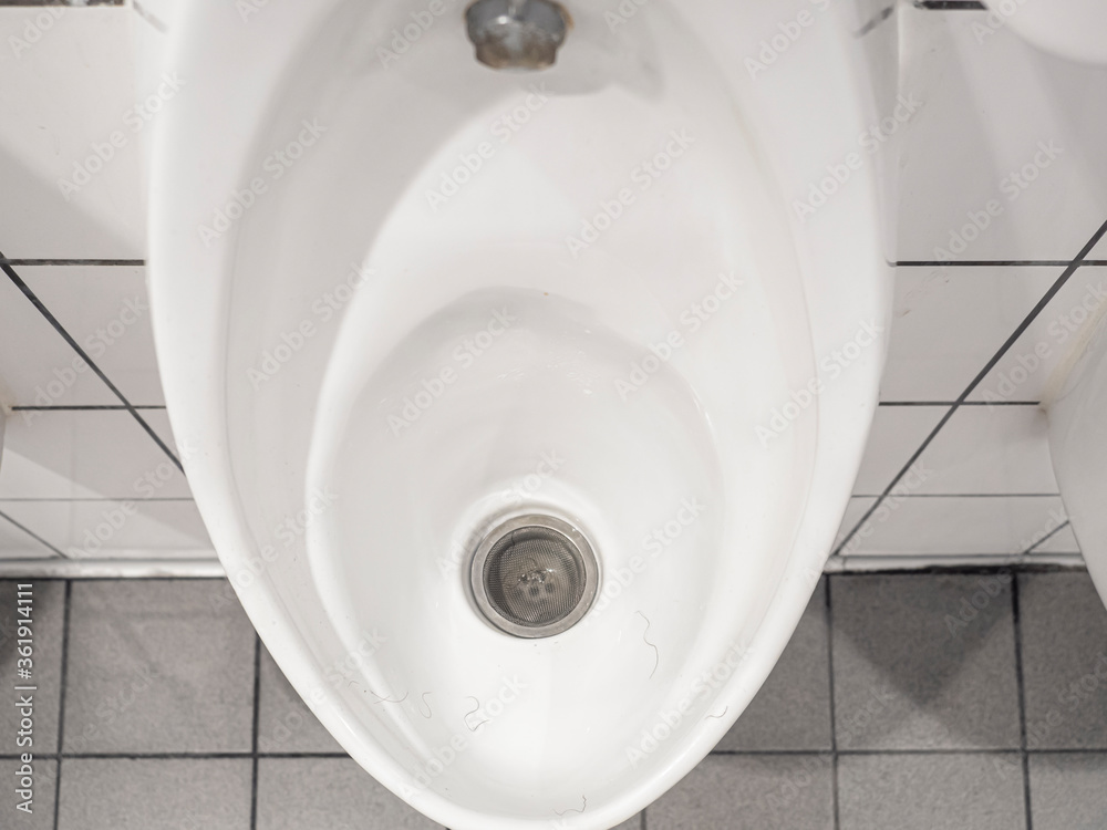 Fototapeta premium White ceramic urinal chamber pot with male public hair. Male hair lost problem.