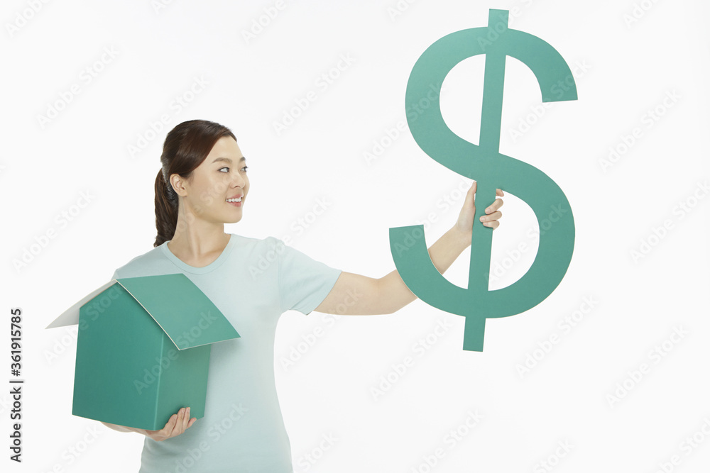 Cheerful woman holding up a dollar sign and a cardboard house Cheerful woman holding up a dollar sign and a cardboard house