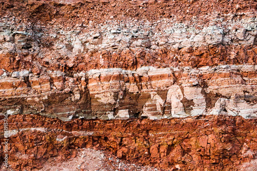 textures of various clay layers underground in clay quarry after geological study of soil. colored layers of clay and stone in section of earth, different rock formations and soil layers.