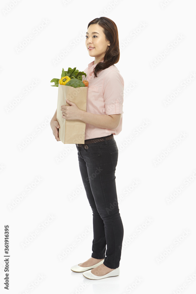Cheerful woman with a bag of groceries Cheerful woman with a bag of groceries