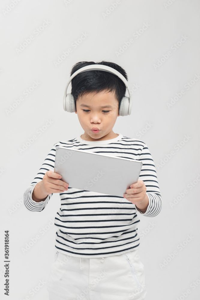 Asian boy laying tablet computer with headset Asian boy laying tablet computer with headset