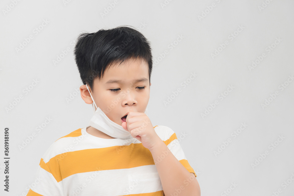 Asian boy with protective mask coughing on white background. Concept of Coronavirus epidemic