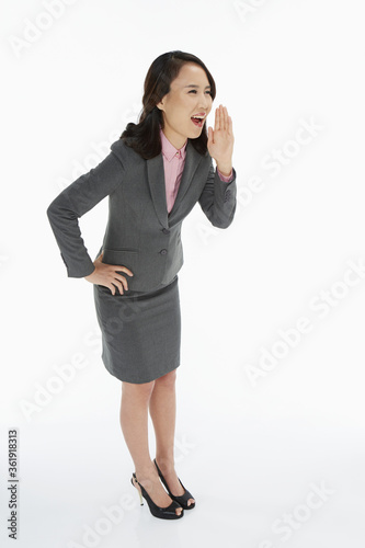 Businesswoman showing a whispering gesture