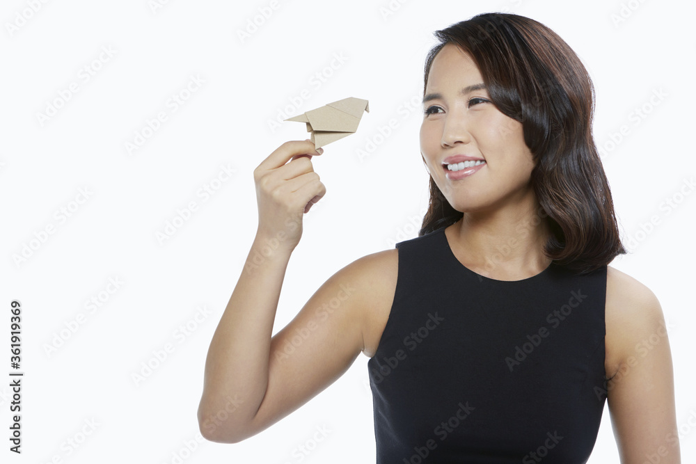 Woman holding up a bird made of cardboard Woman holding up a bird made of cardboard