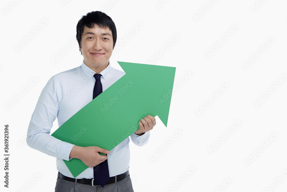 Businessman holding an arrow, pointing to the left Businessman holding an arrow, pointing to the left